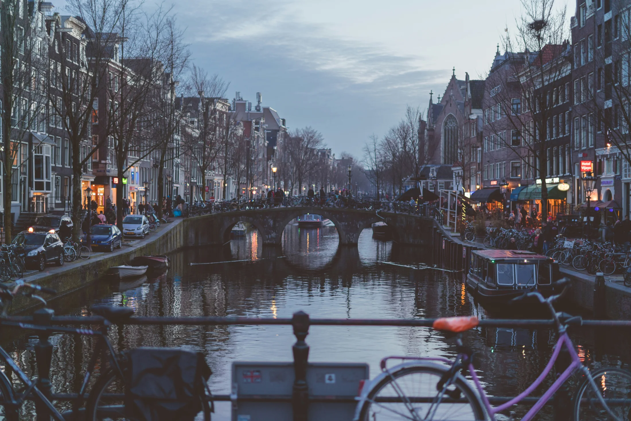 Bicycles beside an Amsterdam canal at dusk