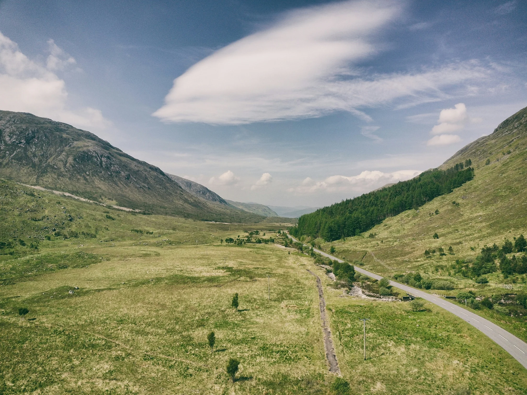 Open road through a wide Highland valley in Scotland