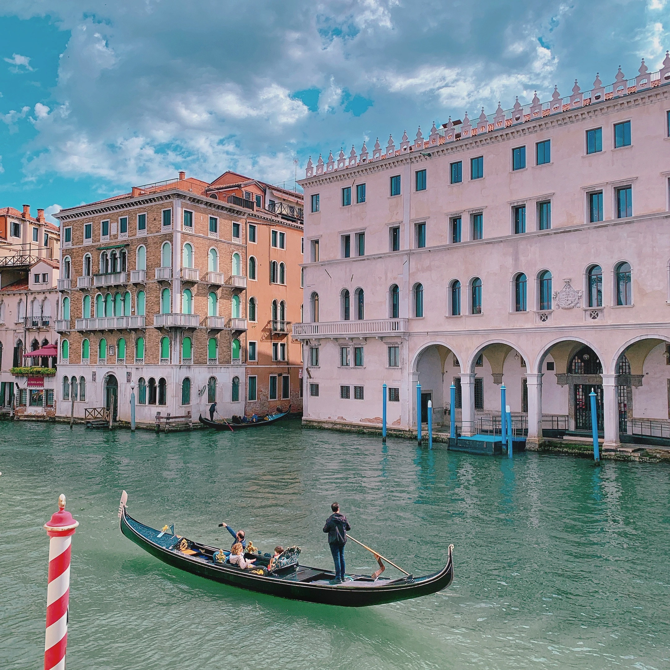 Gondola gliding along a Venice canal with historic buildings and warm light