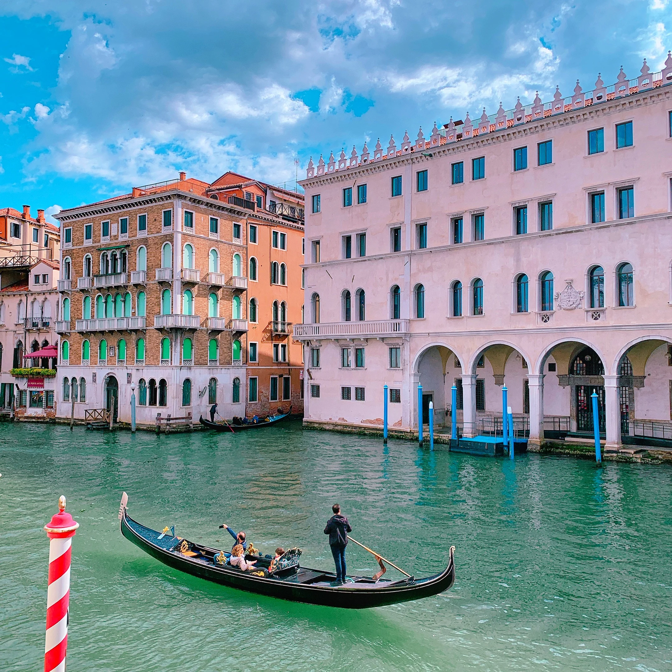 Gondola gliding along a Venice canal with historic buildings and warm light